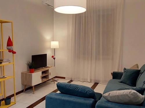 un soggiorno con un divano blu e una televisione di Giulia Town House tra città e mare a Salerno