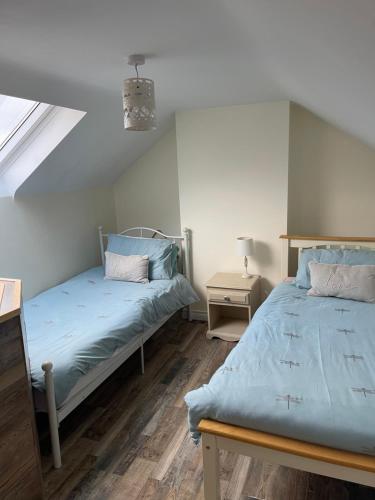 1 dormitorio con 2 camas y ventana en Carrick Lodge Mourne Mountains, en Newry