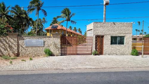 uma casa com um portão e uma cerca em Casa_Mare11 em São Miguel do Gostoso