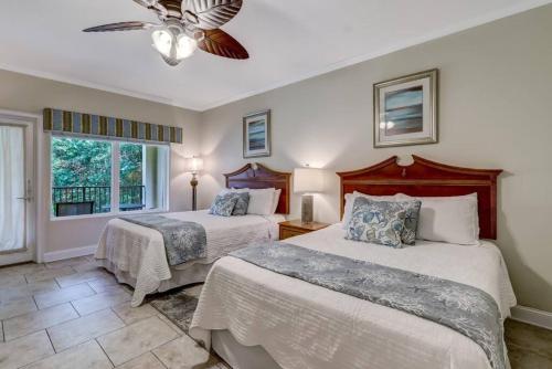 阿米莉亞島的住宿－Comfort and Style at AIP Resort，一间卧室配有两张床和吊扇