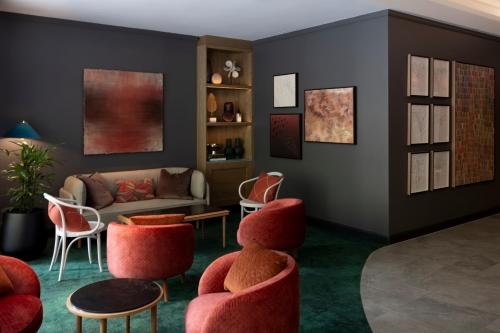 a living room with red chairs and a couch at Novotel Sydney City Centre in Sydney