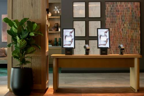 a table with three pictures on it with a potted plant at Novotel Sydney City Centre in Sydney