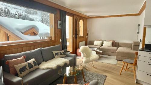 a living room with a couch and a table at Meribel Centre La Chaudanne, real ski in and out, 3 bedrooms 2 bathrooms newly renovated, Chalet l'Épervière in Méribel