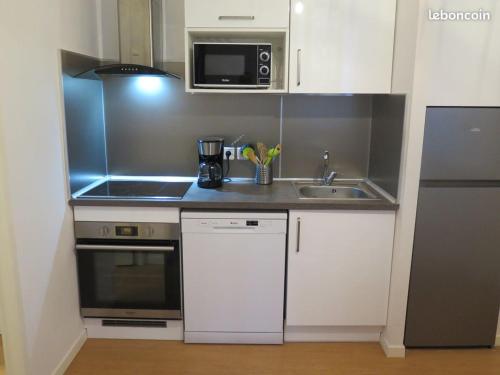 a small kitchen with a sink and a microwave at "Le Desman" Confortable T2 à la montagne face aux thermes RANDO, CURE in Aulus-les-Bains