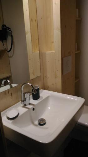 un lavabo blanc dans une salle de bain avec un miroir dans l'établissement Lons appartement T1 centre ville, à Lons-le-Saunier