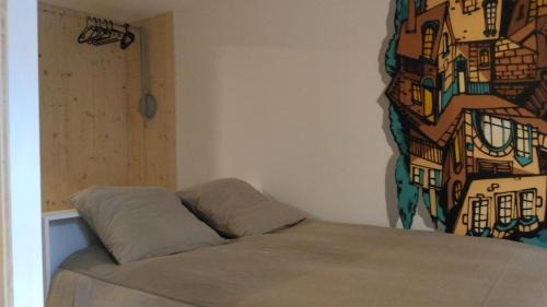 un lit dans une chambre avec un tableau sur le mur dans l'établissement Lons appartement T1 centre ville, à Lons-le-Saunier