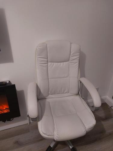 a white chair in a room with a fireplace at De lick strawberry studio in London