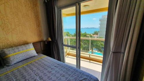 een slaapkamer met een bed en uitzicht op een balkon bij Nautilus Beira Mar in Penha