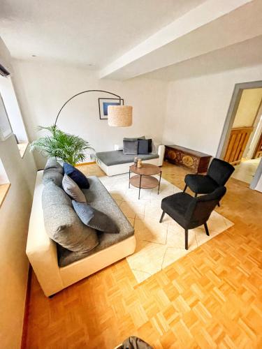 uma sala de estar com um sofá e uma cadeira em Chambre Pin Up Wings em Eguisheim