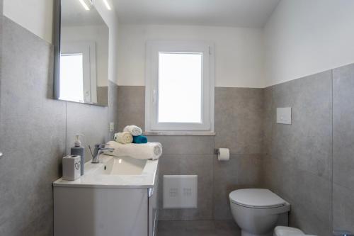 a bathroom with a sink and a toilet and a window at Casa Bijou in Pula