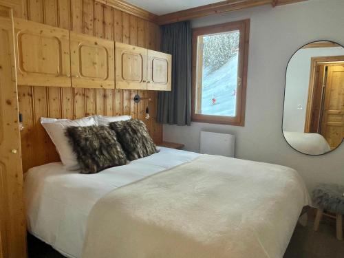 a bedroom with a large white bed and a mirror at Meribel Centre La Chaudanne, real ski in and out, 3 bedrooms 2 bathrooms newly renovated, Chalet l'Épervière in Méribel