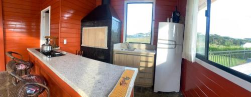 uma pequena cozinha com um balcão e um frigorífico em Recanto do Noah em Painel