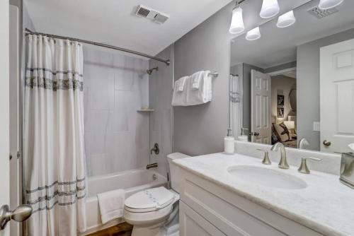 a bathroom with a sink and a toilet and a tub at LUX Oceanfront Retreat at AIPResort in Amelia Island