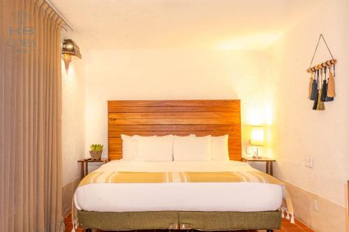 a bedroom with a large bed with a wooden headboard at Kaab Coba in Cobá
