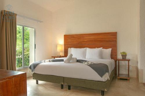 a bedroom with a large bed with a teddy bear on it at Kaab Coba in Cobá