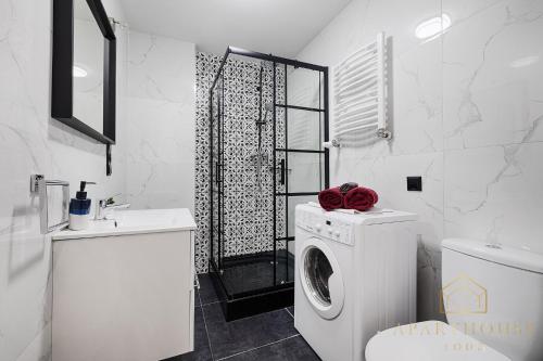 a bathroom with a washing machine and a shower at ApartHouse Center in Łódź