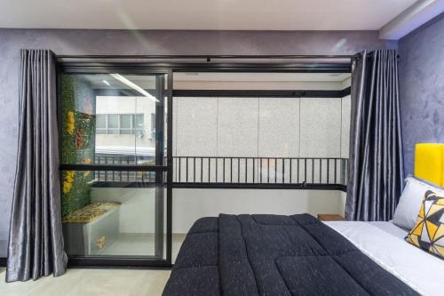 1 dormitorio con cama y ventana grande en MY512 - Bela Vista - Studio Moderno "Próx. a Paulista", en São Paulo