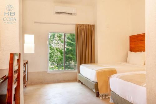a hotel room with two beds and a window at Kaab Coba in Cobá