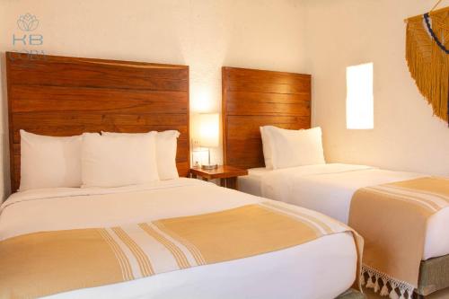 two beds in a hotel room with two beds at Kaab Coba in Cobá