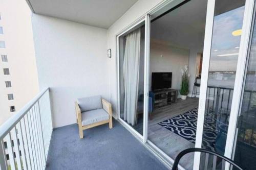 a room with a balcony with a chair and a television at Lakeview newly renovated condo near Disney in Orlando