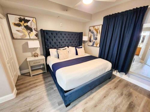 a bedroom with a large bed with a blue headboard at Lakeview newly renovated condo near Disney in Orlando