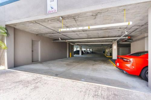 a parking garage with a red car parked in it at Lakeview newly renovated condo near Disney in Orlando
