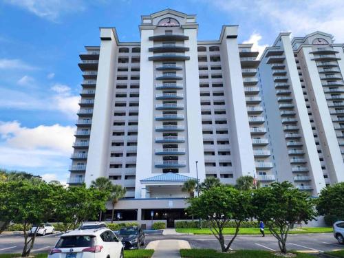 a large white building with cars parked in a parking lot at Lakeview newly renovated condo near Disney in Orlando