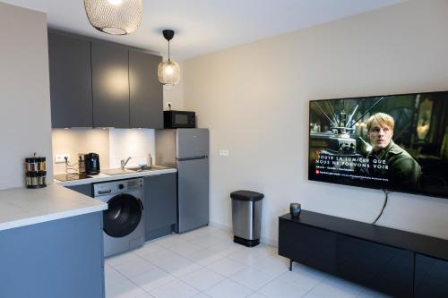 a kitchen with a tv hanging on the wall at Charmant studio en résidence avec parking in Bussy-Saint-Georges