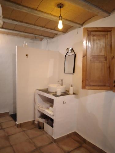 baño con lavabo y armario de madera en COVES DEl XUQUER, en Jorquera