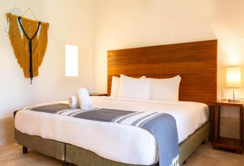a hotel room with a large bed with a wooden headboard at Kaab Coba in Cobá