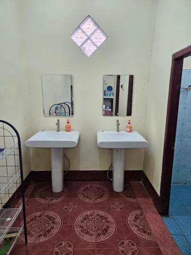 a bathroom with two sinks and a mirror at Kai Lions International Hostel in Paksong