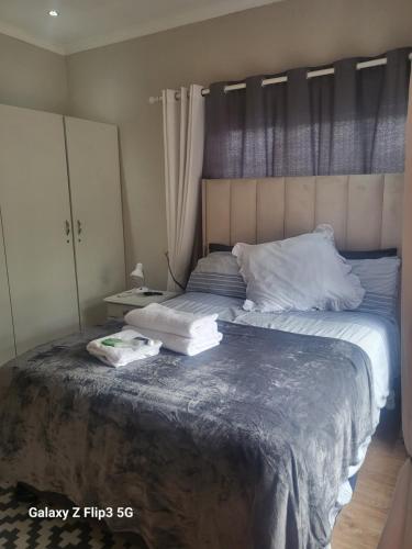 1 dormitorio con 2 camas y almohadas blancas en Lotus 5a en Brakpan