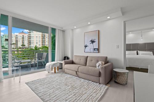 a living room with a couch and a bed at Luxury Condo Hotel with full kitchen, located at 5 mints walk to the beach in Fort Lauderdale