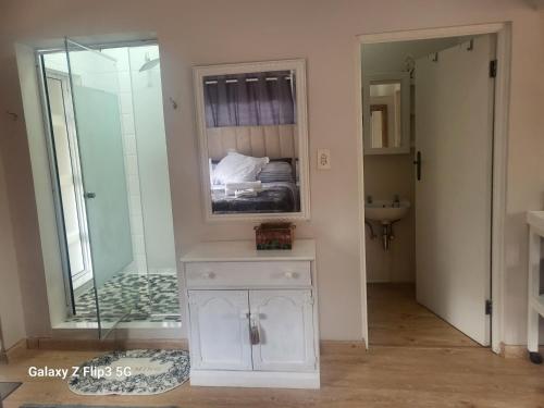 uma casa de banho com um espelho e um quarto com uma cama em Lotus 5a em Brakpan
