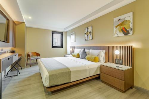 a bedroom with a large bed and a desk at Hotel Flamencos Centro Histórico in Mexico City