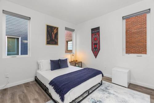 a white bedroom with a bed and two windows at Meleys' Crimson Keep: Driftmark's Suite in Seattle