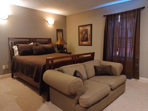 una camera con letto, divano e sedia di Natchez Manor Bed & Breakfast a Natchez