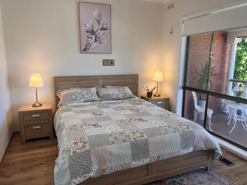 a bedroom with a bed and two lamps and a window at Cozy and nice stay with sunset view! in Mooroolbark