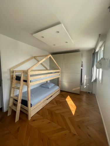 a bunk bed in a room with a wooden floor at Appartement cosy, situé à 5 mins de Roland Garros et du Parc des princes in Boulogne-Billancourt
