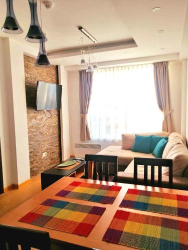 a living room with a table and a couch at Apartman KUTIJA Kopaonik in Kopaonik