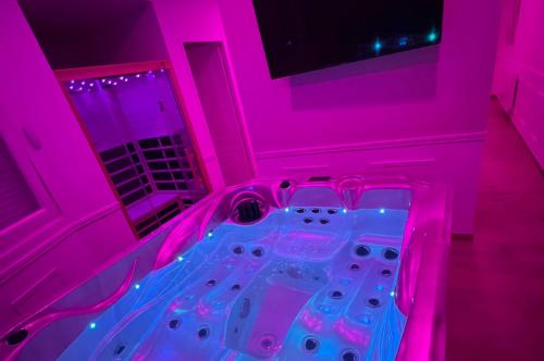 een roze kamer met een hot tub bij Eaux Spa in Rouen