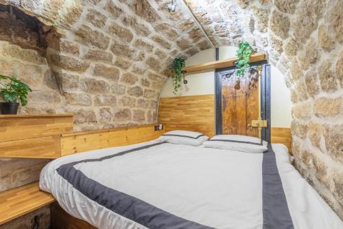 een slaapkamer met een bed in een stenen muur bij Incroyable appartement Parisien in Parijs