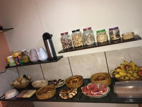 a counter with bowls of food and baskets of fruit at Aconchego do céu in Conceição da Ibitipoca