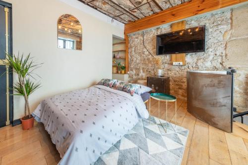 een slaapkamer met een bed en een stenen muur bij Incroyable appartement Parisien in Parijs