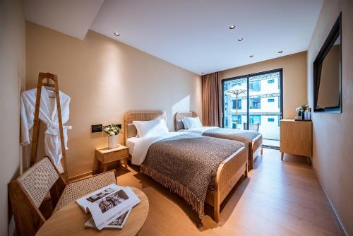 Habitación de hotel con 2 camas y TV en Qingdu - LiYuan Hotel, en Dali