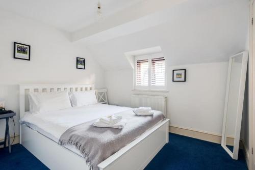 a bedroom with a white bed with two towels on it at Cosy 2-Bedroom Haven in Picturesque Headington in Oxford