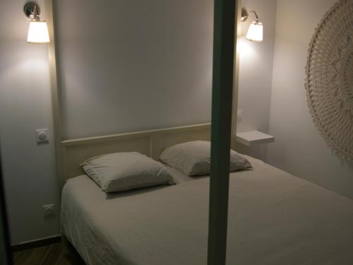 een slaapkamer met een bed met 2 kussens erop bij Eaux Spa in Rouen