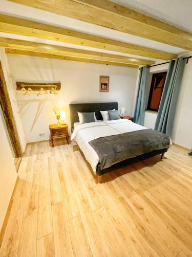 um quarto com uma cama grande e piso em madeira em Chambre Super Broussard em Eguisheim