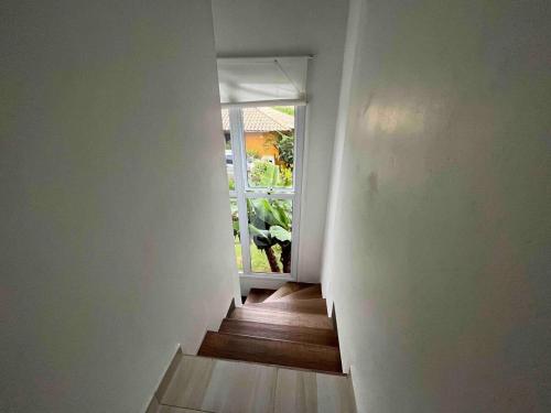 a hallway with a stairway with a window at São Francisco do Sul, SC, Praia do Forte. in São Francisco do Sul