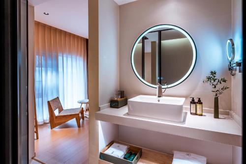 Qingdu - LiYuan Hotel في دالي: حمام مع حوض ومرآة